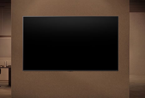 A wall-mounted LG TV with its display switched off showing how the TV's motion sensors can intelligently adjust depending on the detected motion nearby.