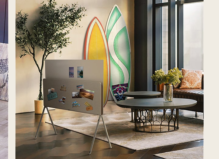 A slide show opens with LG OLED Posé seen from the back with a vinyl album and record placed on the media shelf, next to vinyl records and a guitar. Next, LG OLED Posé is seen from the back with nature magazines placed on the media shelf in a plant-themed living room. Then, LG OLED Posé is seen from the back with postcards, a license plate sticker, photos, and pins placed all over the back as it sits in a warm, bright living room.