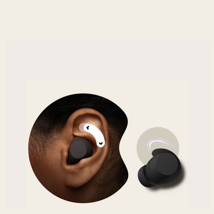 A person's left ear with a unit of white xboom Buds in it. Above the earbud, there's a two-way arrow.	