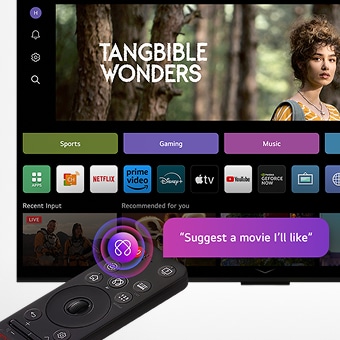 On an LG OLED TV screen is the webOS 25 home page filled with apps and entertainment content. By the TV is the LG AI Magic Remote, the AI button is highlighted as if activated by the user's voice. A speech bubble is beside it, "suggest a movie I'll like"