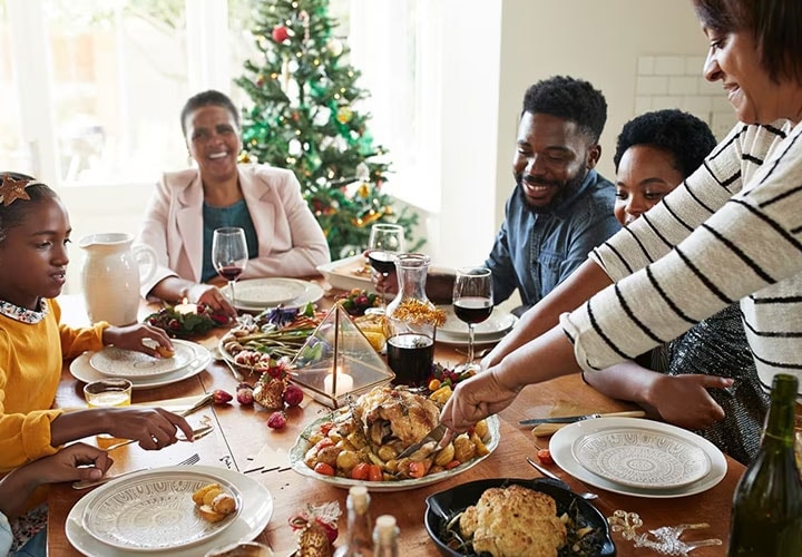 A family enjoys dinner before storing their holiday leftovers in the fridge