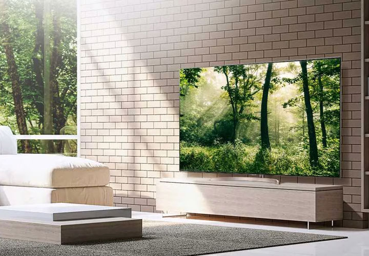 The LG Super UHD Nanocell TV, located in a living room, displaying a vibrant image of a forest.