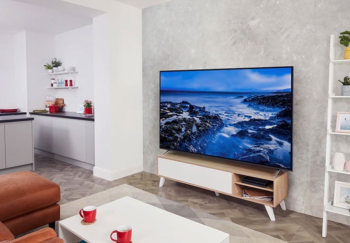 A living room with LG TV displaying a picture a rocky shore