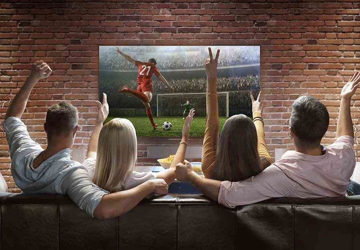 A group of friends watching a sport match from lg super uhd 4k tv.