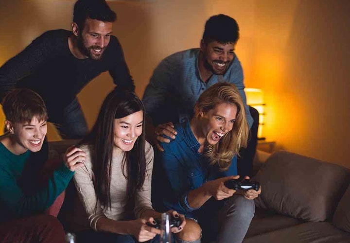 A group of friends playing a video game on a lg super uhd 4k tv