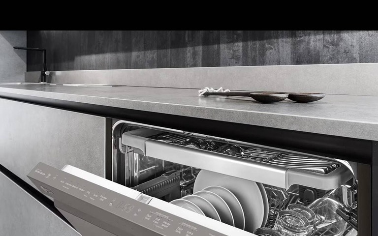 A sleek, built-in LG dishwasher partially opened in a modern kitchen with a minimalist design, showing clean dishes neatly arranged inside.