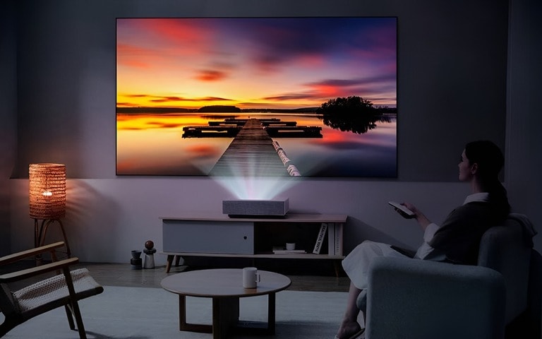 A home theatre setup with an LG projector delivering a stunning sunset scene in 4K, offering an immersive viewing experience in a living room setting.