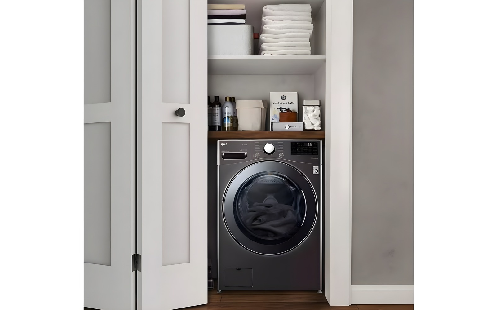 LG washing machine in a compact closet with neatly organised shelves holding towels and laundry supplies, highlighting an efficient use of space.