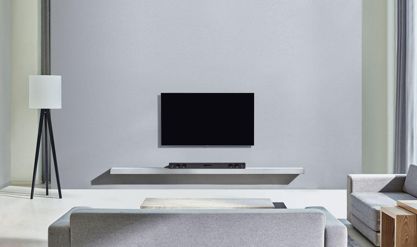 TV and Soundbar centred around a grey background, facing a grey living room sofa