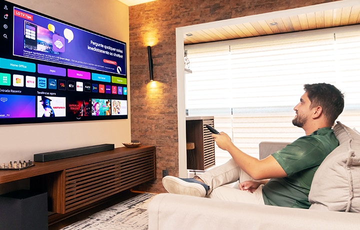 Man using a controller on his LG TV sat in his living room