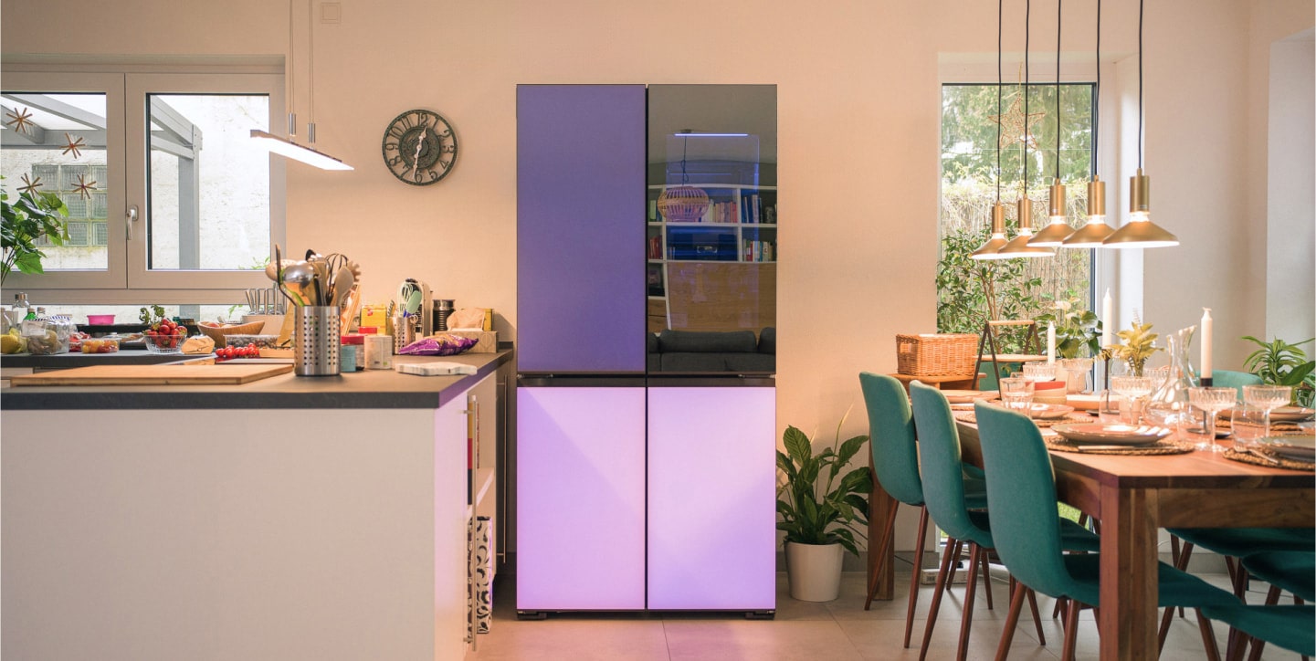 MoodUP refrigerator illuminated by LED light panels located between kitchen island and dining tables.