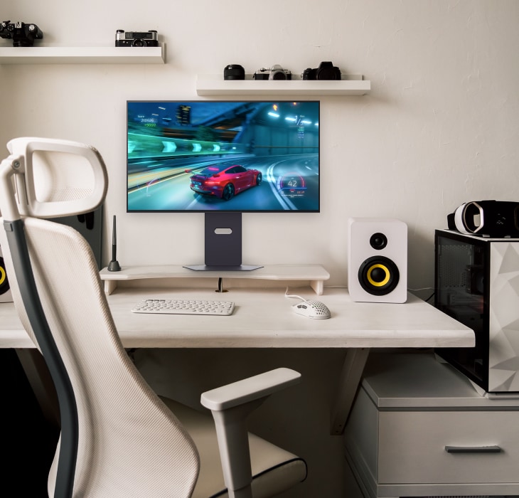 The LG UltraGear Gaming monitor is on a clean gaming desk, displaying a racing game.