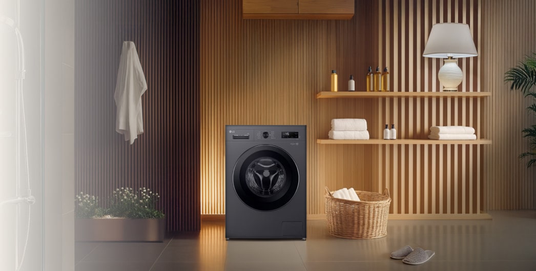 LG washing machine in a cozy laundry room with wooden shelves, plants, and neatly folded towels.