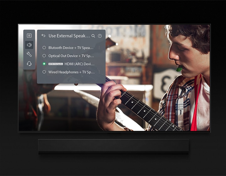 An image of an LG OLED TV with Soundbar. A video of a boy playing the guitar plays on screen with Soundbar Mode's settings overlayed on top.