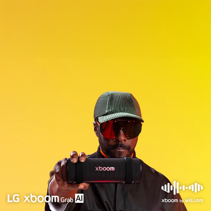 will.i.am in black outfit and sunglasses is holding xboom Grab on his shoulder.