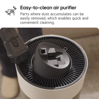 Top view of an LG air purifier being cleaned with a brush attachment. Text reads: 'Easy-to-clean air purifier: Parts where dust accumulates can be easily removed, enabling quick and convenient cleaning.'