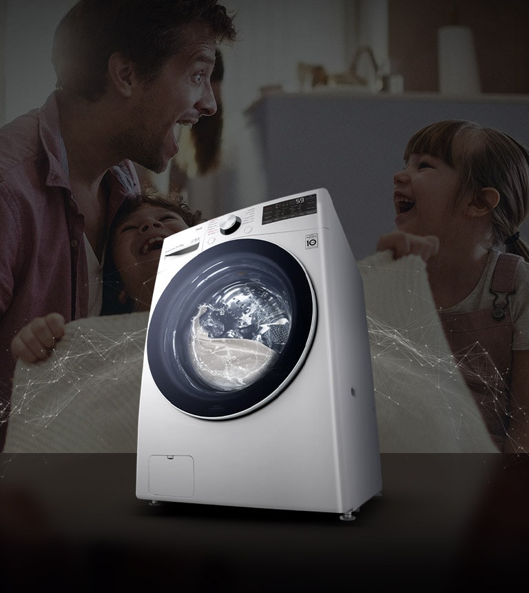 Bố và con gái đang cười ở phía sau trong lúc cầm một cái chăn sạch. Máy giặt cửa trước màu trắng ở phía trước.
