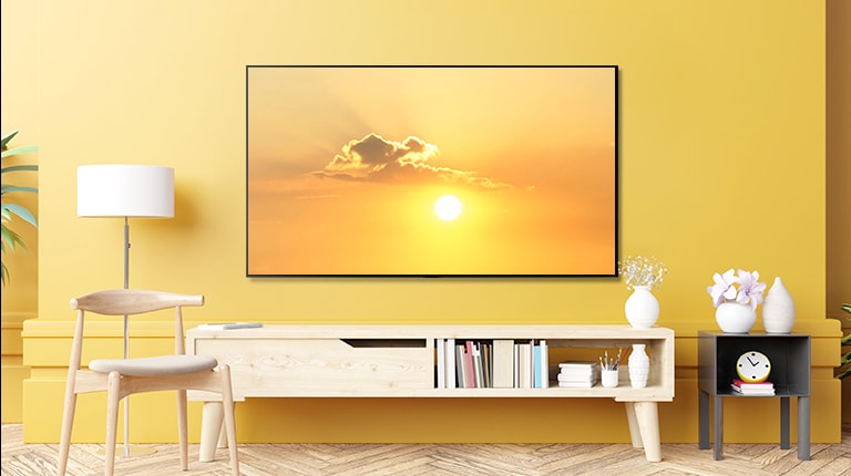 TV trong phòng khách hiển thị một con chim bay trên bầu trời màu vàng và cảnh chuyển sang hiển thị TV được đặt trong phòng ngủ hiển thị cùng một kênh.