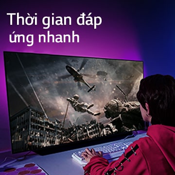 Một cô gái đang chơi game máy tính với TV màn hình lớn hiển thị hình ảnh một người lính lao từ trực thăng xuống.