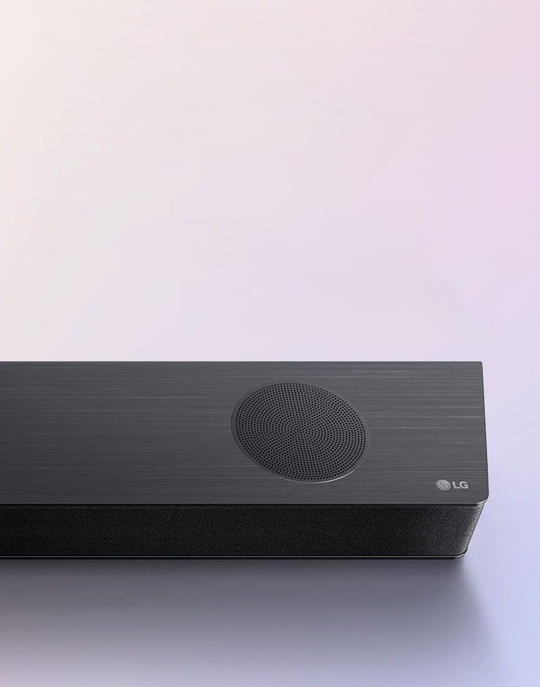 LG Sound Bar is place on the ground, showing LG logo right corner of the sound bar. Alexa logo and OK GOOGLE logos are placed on the sound bar.