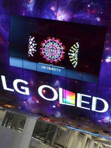 A curved OLED screen installation reading "LG OLED