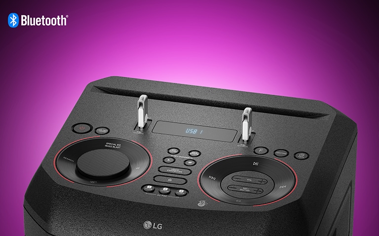 A closeup view of controls on top of LG XBOOM, with two USBs plugged in. A Bluetooth logo is shown in the upper left corner.