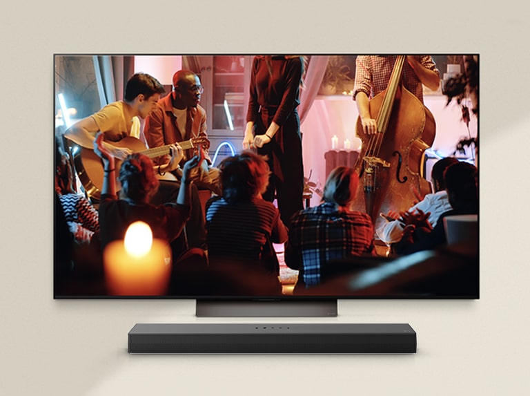 A cozy concert is playing on an LG TV with an LG Soundbar underneath.