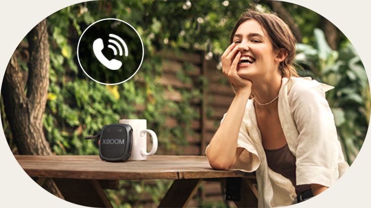 A woman is talking on the phone through LG XBOOM XG2 Speaker phone mode.