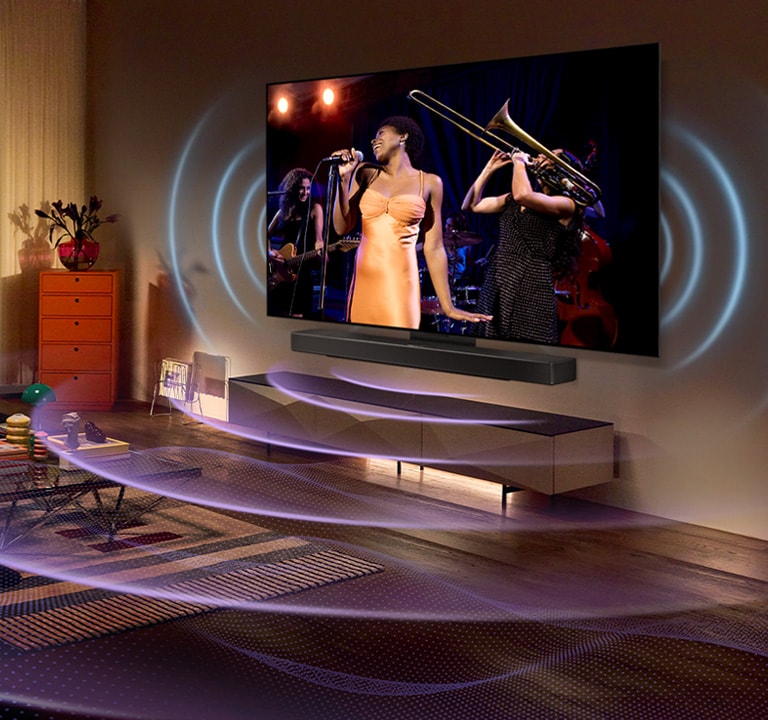 An image of an LG OLED TV in a room showing a music concert. Blue curved lines depicting TV sound and purple curved lines expressing Soundbar sound fill the space.