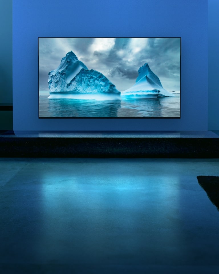 A blue neon circuit moves around on blue glacier image. The camera zooms out and shows this blue glacier within TV screen. The TV is placed in a wide living room with blue background.