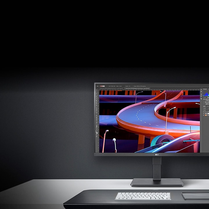 Moniteur de LG sur un bureau minimaliste affichant des illustrations numériques de routes courbes colorées dans un programme de conception graphique