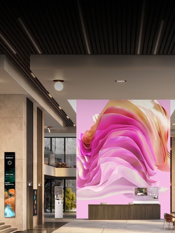 Divers écrans d’affichage numérique dans un hall d’entreprise accueillant les visiteurs dans une atmosphère élégante et montrant du contenu informatif.