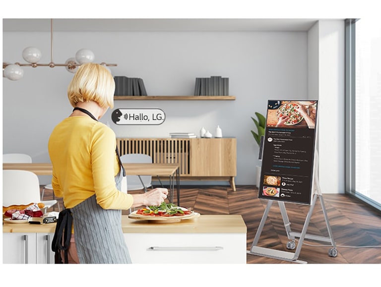 Eine Frau steuert den One:Quick Flex beim Kochen per Sprachbefehl.