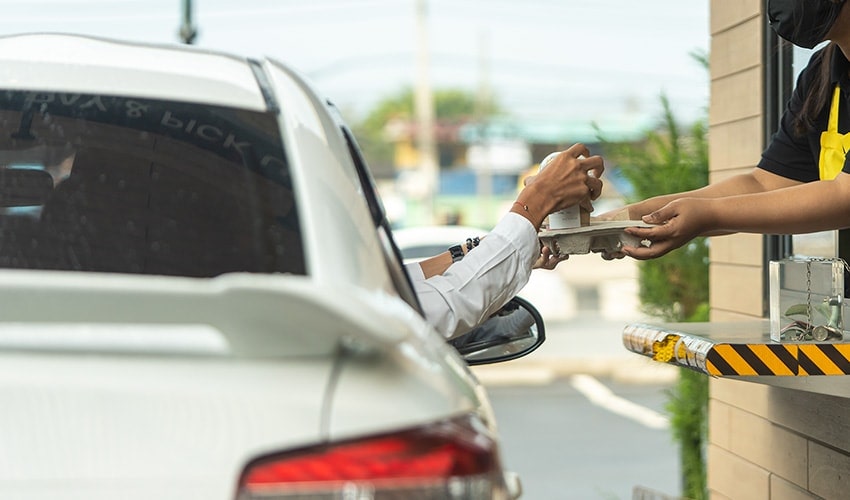 An image of a person in the car using drive thru