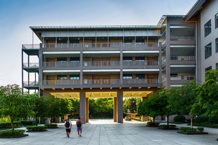 Residential building with open courtyard and walkway surrounded by greenery