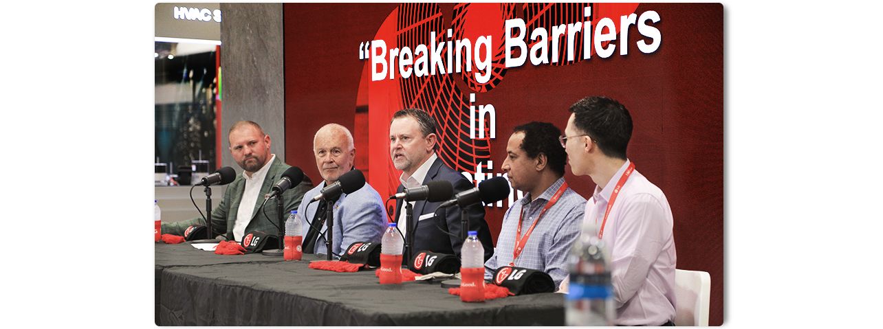 Breaking Barriers panel at a conference discussing business and technology, featuring industry professionals.