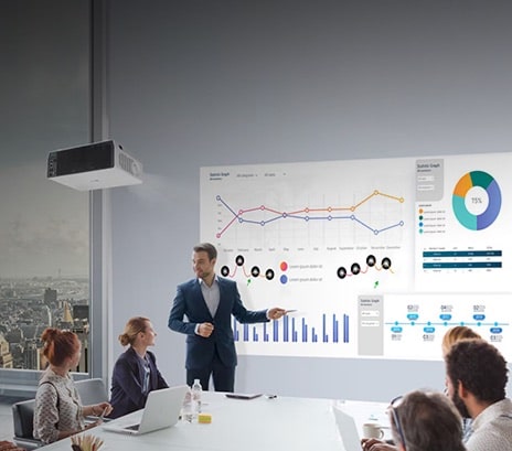 Professional giving a presentation with charts on a large projected screen in a meeting room, representing LG projectors.