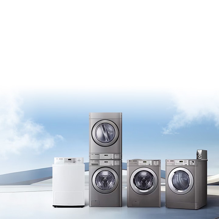 Lineup of LG commercial laundry machines displayed outdoors under a blue sky, including dryers, front-load washers, and stacked washer-dryer units in stainless steel finish