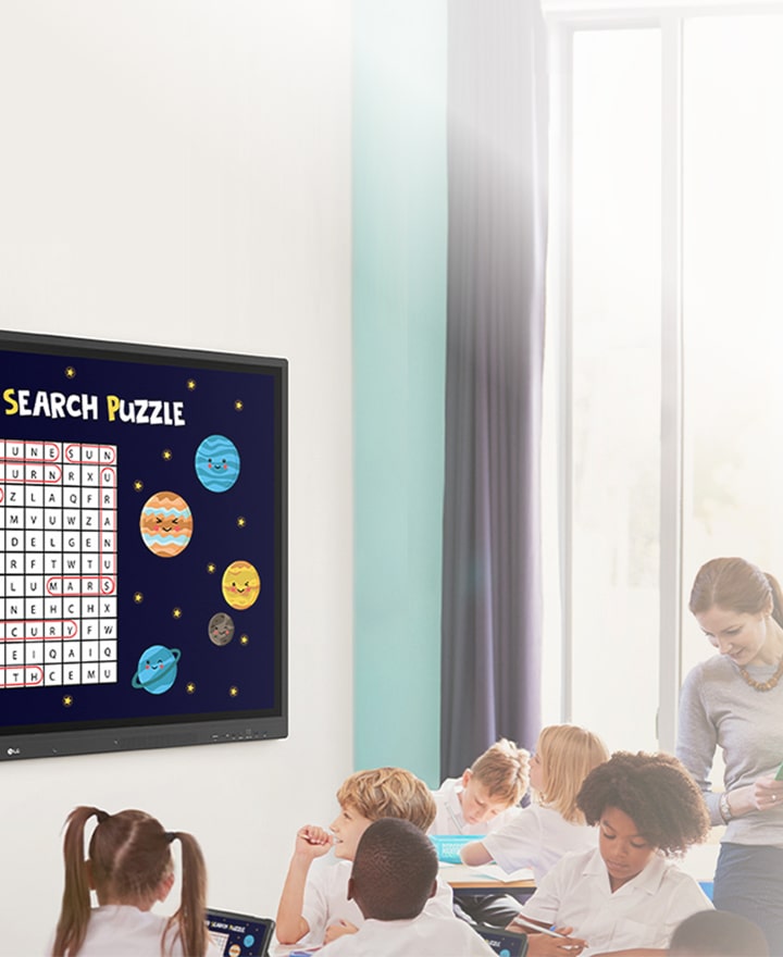 LG Digital Signage in a classroom displaying an interactive space-themed word search. LG education display solutions designed to enhance student engagement through dynamic content and vivid visuals.
