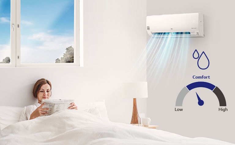 An image of a woman reading on her bed with air conditioning on.