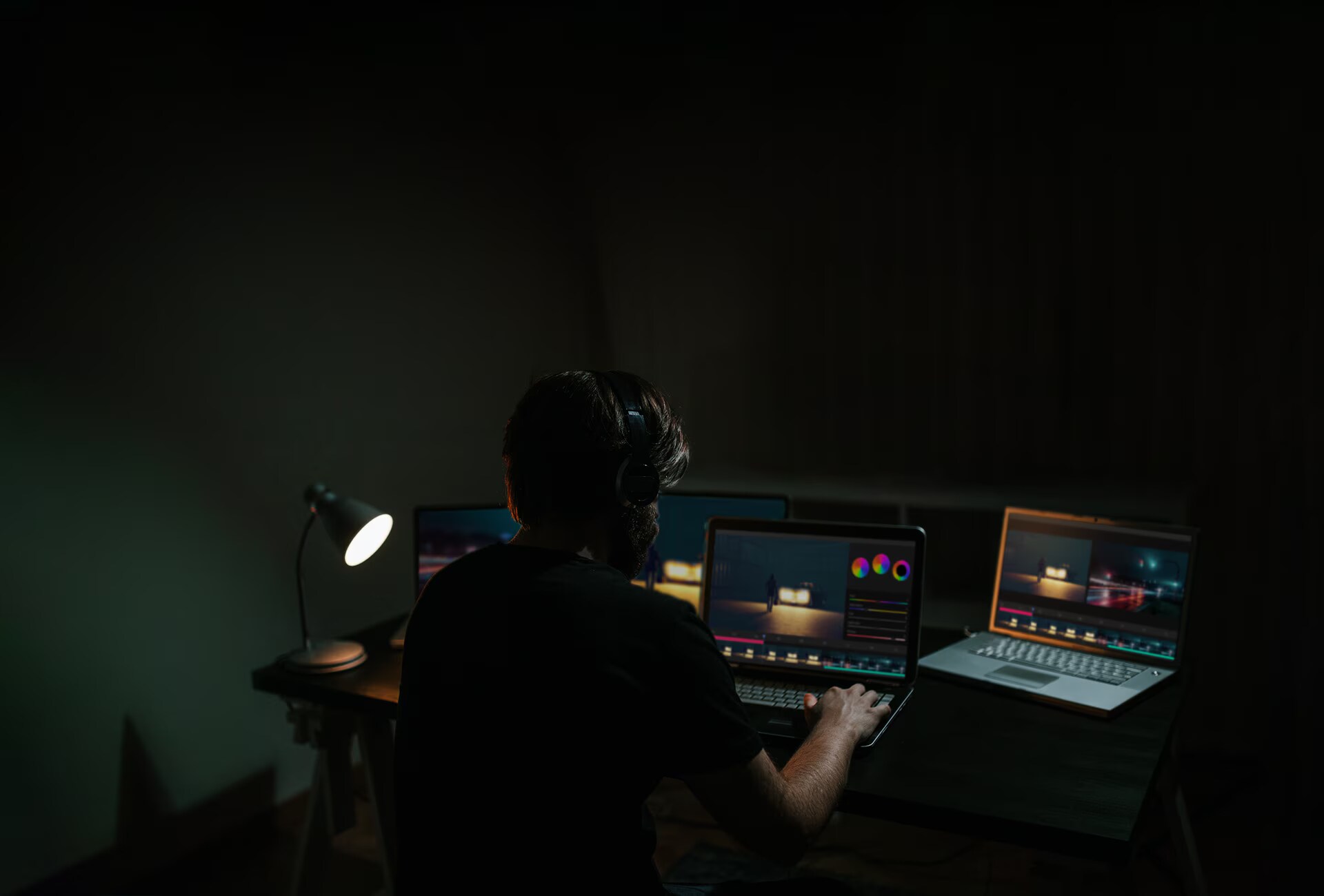 Ein Mann schneidet einen Film, während er einen Computermonitor mit Software darauf betrachtet