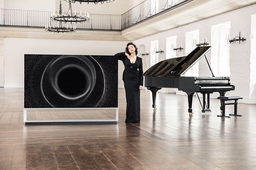 Khatia Buniatishvili next to the LG SIGNATURE 8K OLED TV Z1 and a piano.