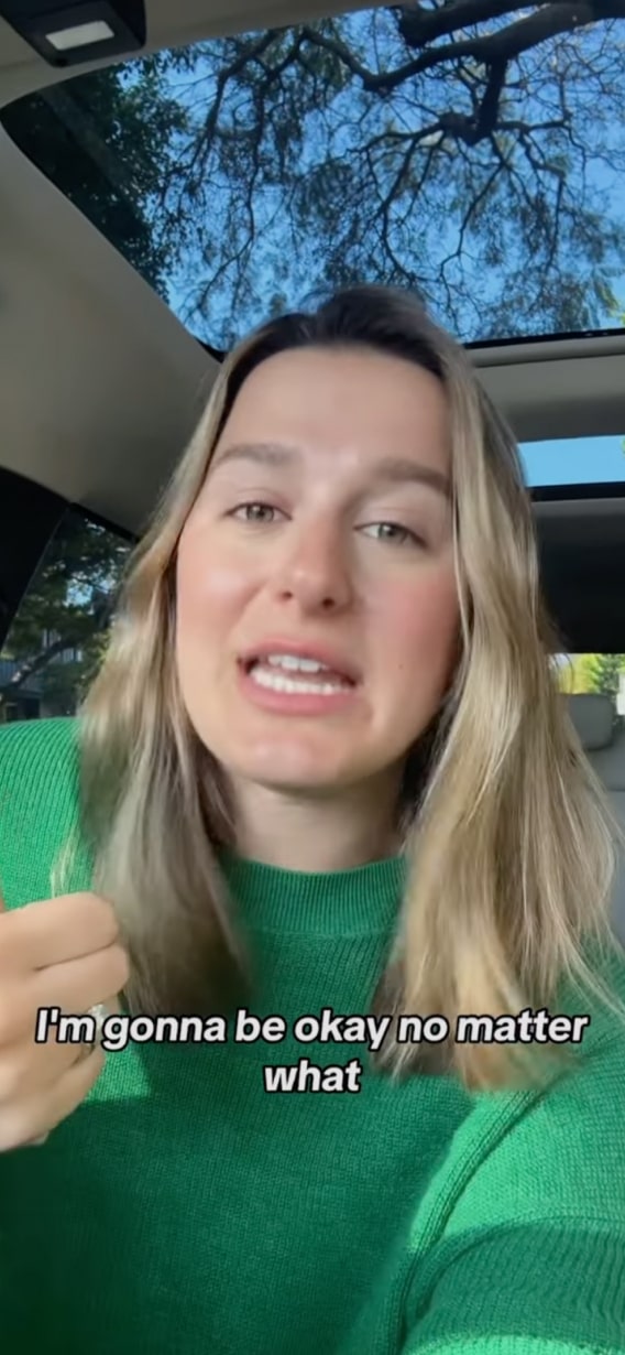 Woman speaking inside a car with the text 'I'm gonna be okay no matter what' at the bottom.