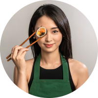 Tina Choi segurando de forma divertida um pedaço de kimbap perto do olho.