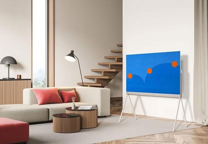Uma sala de estar elegante e moderna com uma TV LG OLED em um suporte minimalista, projetado para combinar com a decoração contemporânea.