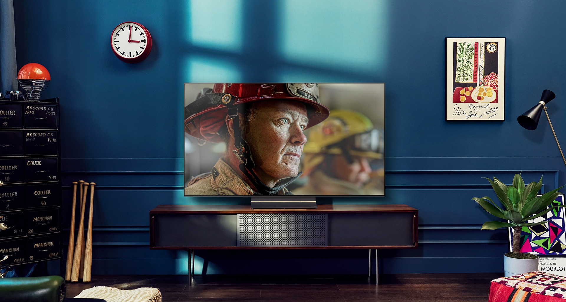 Un LG OLED TV de pared está en una habitación blanca y brillante con decoración en tonos naturales. A medida que la pantalla se mueve, la escena cambia del día a la noche. with Logo Dolby Vision IQ