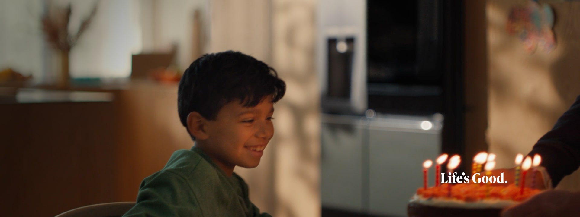 Le visage de l'enfant est clairement visible devant le gâteau aux chandelles et le réfrigérateur LG InstaView est est à peine visible en arrière-plan.