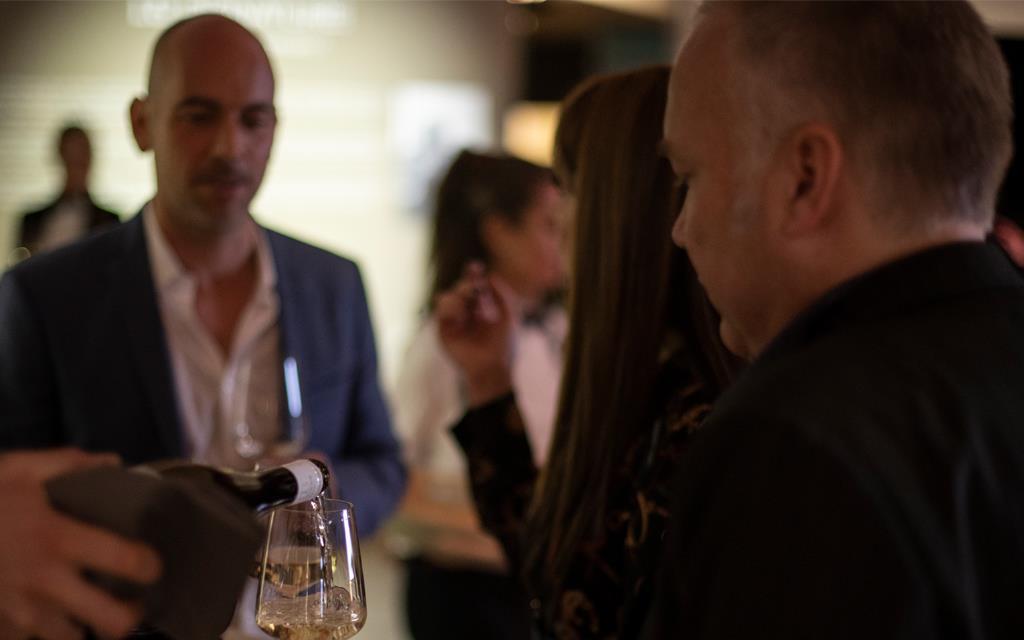 A representative for Allendorf Wines pours a glass during a wine tasting at LG SIGNATURE ARTWEEK