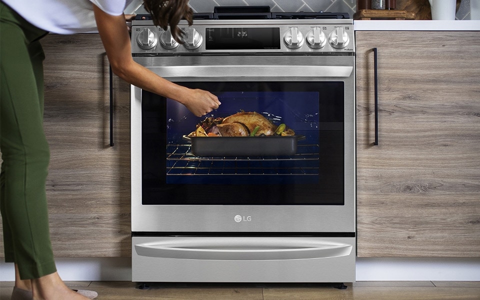 A woman checking her LG Instaview oven, introduced by LG at CES 2021