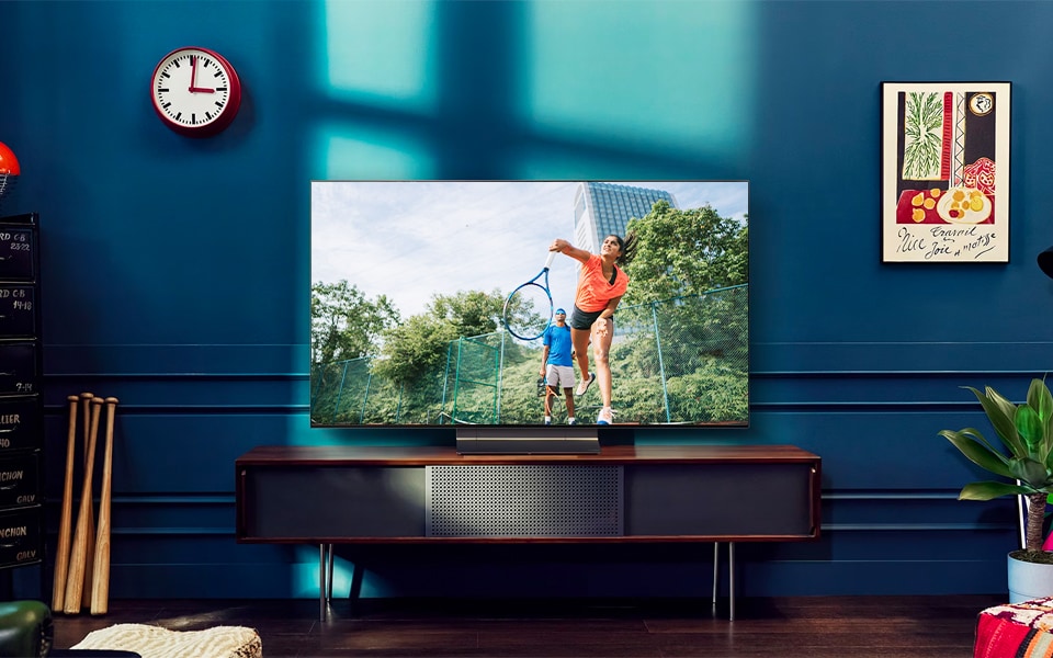 Three people watch a soccer match an on OLED evo smart TV